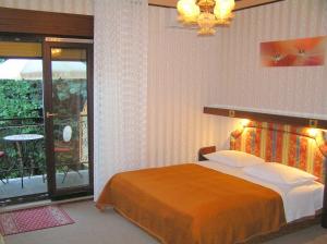 a bedroom with a bed and a balcony with a table at Guest House Lifestyle Holiday in Opatija