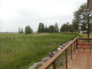 a wooden deck with a bench and a field at Treimani Rannamaja in Treimani