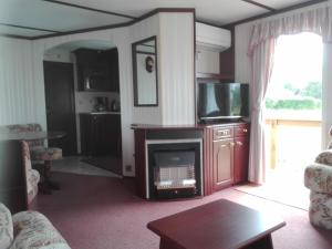 a living room with a fireplace and a tv at Treimani Rannamaja in Treimani