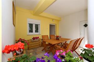 a patio with a wooden table and chairs and flowers at Apartments Maruna Self check-in in Zadar +60 photos