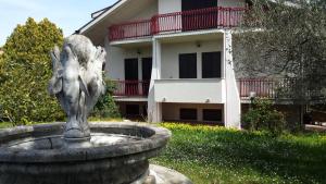 a statue in a fountain in front of a house at La villa più bella con piscina in Treglio