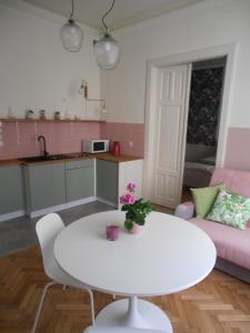 cocina y sala de estar con mesa blanca y sofá en Apartamenty Rudi, en Cracovia