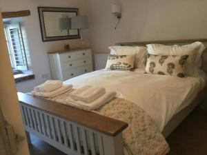 a bedroom with a bed with towels on it at Pilchards Cottage in Noss Mayo