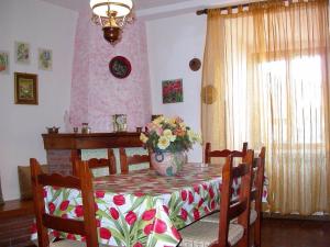 a dining room table with a vase of flowers on it at Casa del Ciliegio in Radicofani