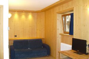 a living room with a blue couch and a television at Casa Vacanze Sablonera in Bormio