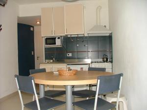 cocina con mesa y sillas en una habitación en Al Mar Departamentos en Puerto Madryn