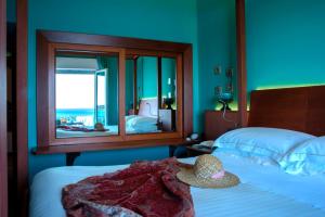 a bedroom with a bed with a hat on it at Hotel Palladio in Giardini Naxos