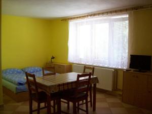 a dining room with a table and a bed and a window at Ubytovani u Lysonku in Klentnice