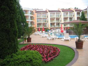 a hotel with a flower garden in front of a pool at Sun City Hotel in Sunny Beach