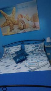 ポルトパーロにあるB&B Stella Marinaのベッド1台(壁に絵が描かれた青いヘッドボード付)