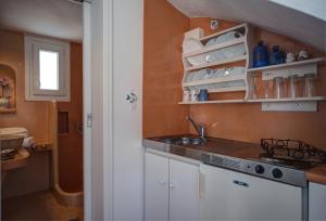 a kitchen with white cabinets and a sink and a window at Porto Vlastos in Agios Ioannis