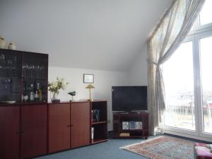 a living room with a tv and a large window at Ferienwohnung Marina Cux in Cuxhaven