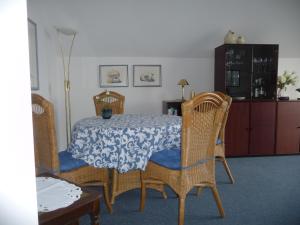 a dining room with a table and wicker chairs at Ferienwohnung Marina Cux in Cuxhaven