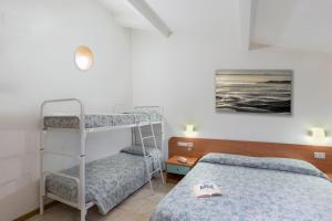 a bedroom with two bunk beds and a painting at Hotel Darsena in Passignano sul Trasimeno +44 photos