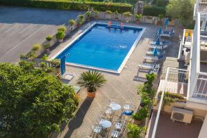 an overhead view of a swimming pool with tables and chairs at Hotel Darsena in Passignano sul Trasimeno