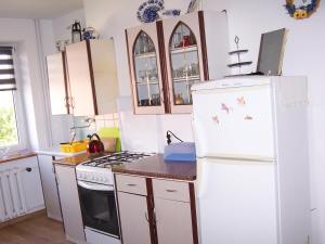 a kitchen with a white refrigerator and a stove at Agrohotelik-gospodarstwo agroturystyczne in Mrągowo
