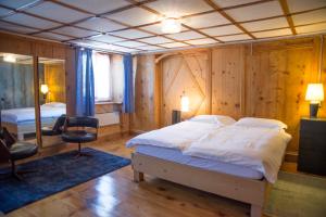 a bedroom with a large bed and a mirror at Hotel Vittoria - Ca' De La Montagna in Montespluga