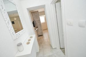 a white bathroom with a sink and a mirror at Bay View Apartments in Kotor