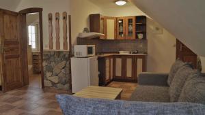 a kitchen with a couch and a kitchen with a refrigerator at Penzion Ostruznik in Ostružná