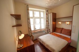 niewielka sypialnia z łóżkiem i oknem w obiekcie My place in Poznan w Poznaniu