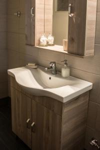 uma casa de banho com um lavatório branco e um espelho. em Alexandra Apartment Near Chania Center em Chania Town