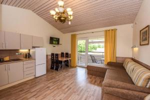 a large living room with a couch and a kitchen at Apartamentai Trys pušys in Šventoji