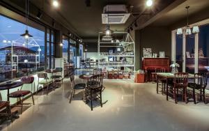 a restaurant with tables and chairs and windows at Yeosu Blooming Pension in Yeosu