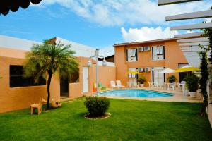 a house with a yard with a swimming pool at Hotel Terra do Sol in Aracaju