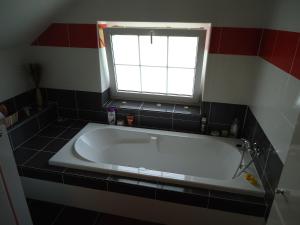 a bath tub in a bathroom with a window at Cyklonocleh in Veselí nad Moravou