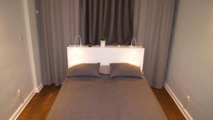 a large bed in a room with a white wall at Home3city Kameralny in Sopot