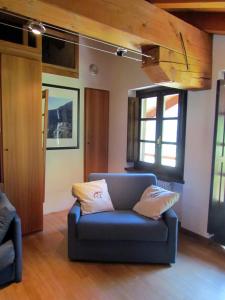 sala de estar con sofá azul y ventanas en Il Piccolo Residence, en Gressoney-la-Trinité