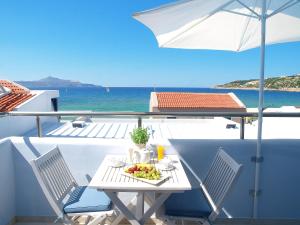 a table with a plate of food and an umbrella at Almiris Seaside Apartments in Almirida
