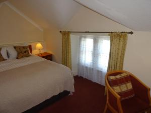 a bedroom with a bed and a window with curtains at Lutwidge Arms in Holmrook
