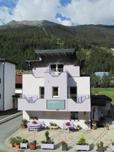 a white building in front of a mountain at Alpenapart Saphir in Sölden