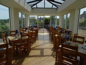 a restaurant with tables and chairs and windows at Lutwidge Arms in Holmrook