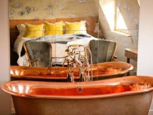 una vasca da bagno in una camera con un letto di Bingham Riverhouse a Richmond upon Thames