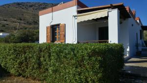 a house with a hedge in front of it at Tramonto Nel Delfini in Kini