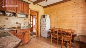 Una cocina con refrigerador blanco y gabinetes de madera. en Goryanka, en Yaremche