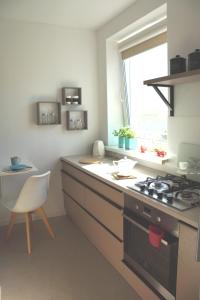 y cocina con fogones y silla. en APARTAMENT KOŁOBRZEG, en Kołobrzeg