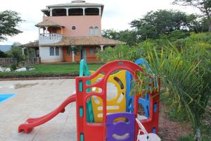 a playground in front of a house with a tower at Pousada Florada na Serra in Serra do Cipo