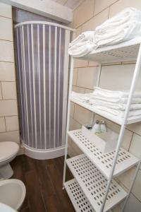 La salle de bains est pourvue de toilettes et d'une étagère avec des serviettes. dans l'établissement Rifugio Massafera, à Massafra