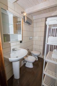 La salle de bains est pourvue d'un lavabo, de toilettes et d'un miroir. dans l'établissement Rifugio Massafera, à Massafra