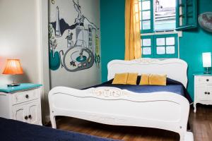 um quarto com 2 camas brancas e uma parede azul em Hostal Forestal em Santiago