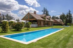 a house with a swimming pool in the yard at La Palma Polo Hotel - Airport Area in Puembo