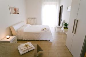 a white bedroom with a bed and a couch at La Residenza di Bacco in Cannara