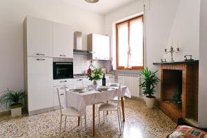 a white kitchen with a table and a fireplace at La Residenza di Bacco in Cannara