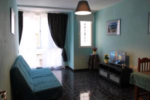 a living room with a blue couch and a television at el Bounty de Playa Chica in Puerto del Rosario