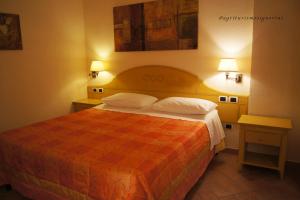 a hotel room with a large bed with two lamps at Agriturismo Signorini in Orciatico