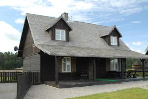 a black house with a gambrel roof at Osada Rydzewo in Rydzewo