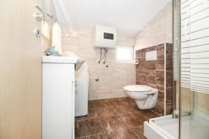 een badkamer met een toilet, een wastafel en een douche bij Apartments Nela in Podstrana
